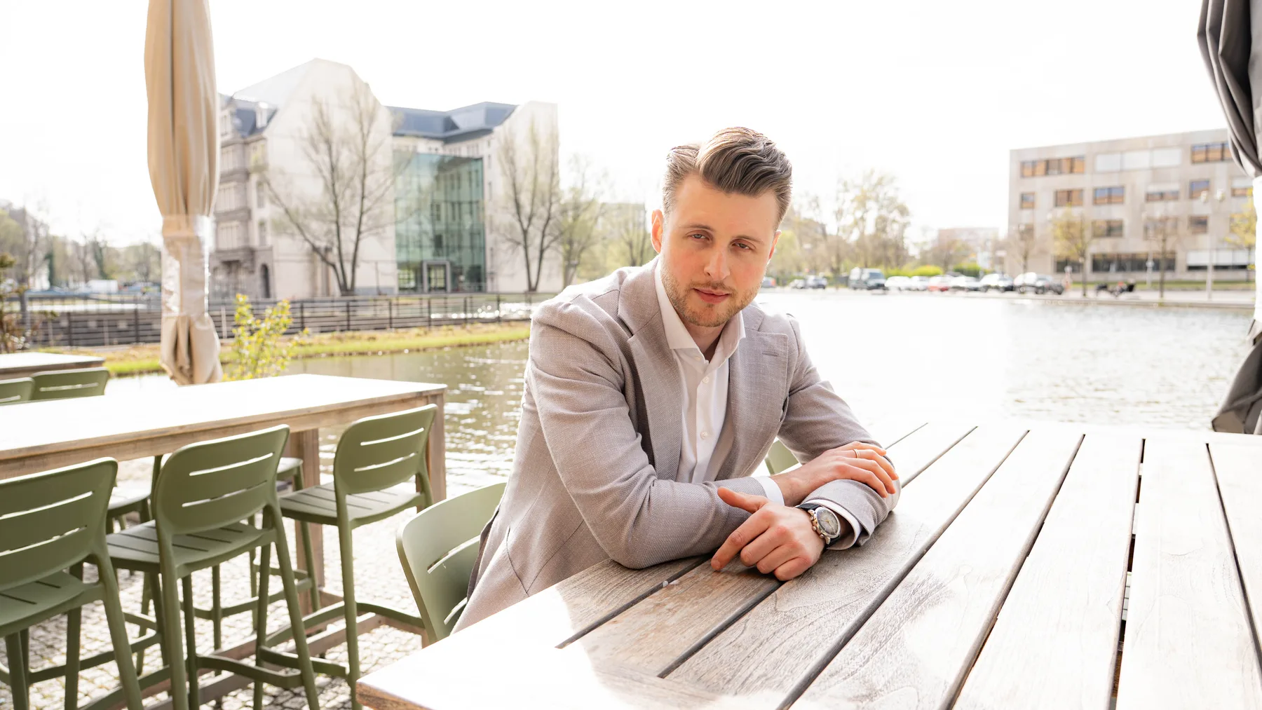 Julian Bilek an einem Tisch am Wasser in Berlin